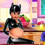 En gravid kvinne i svart latexdrakt med kattelue sitter ved et bord i et fargerikt rom med blomster og stearinlys
