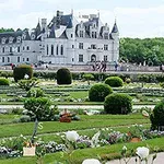Et storslått slott med en elegant hage fylt med velstelte busker og blomster