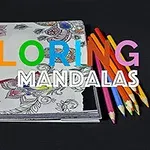 Fargeblyanter og et fargeleggingshefte med mandala-design på en svart bakgrunn