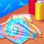 Fargerik tie-dye t-skjorte med spiraldesign ved siden av flasker med farge på et bord