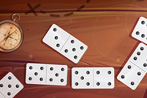 Domino-brikker og kompass på en brun bakgrunn