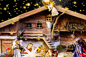 Julekrybbe med figurer av Maria, Josef, Jesusbarnet og vise menn foran en stall med en engel på taket og stjerner i bakgrunnen