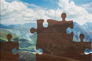 En fjellandskap med store trepuslespillbrikker plassert over bildet