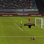 En fotballspiller skyter en ball mot et mål mens en dommer, en annen spiller på en trampoline, og en liggende spiller vises på banen