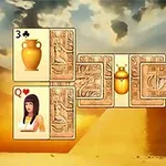Spillekort med egyptiske temaer og symboler vises mot en bakgrunn av pyramider og himmel