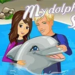 To personer og en delfin i et basseng med teksten My Dolphin Show 2 i bakgrunnen