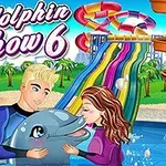To personer klemmer en delfin foran en fargerik vannsklie i en tropisk temapark