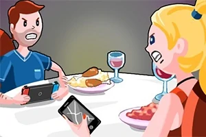 To personer sitter ved et bord med talerken med mat og drikker vin, der den ene holder en spillkonsoll og den andre en telefon