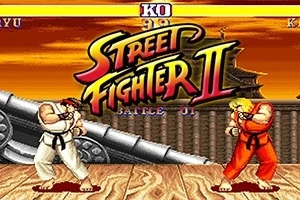 To karakterer i kampstilling foran en stor kanon med solnedgang i bakgrunnen, med Street Fighter II logo i midten