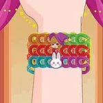 En arm med fargerike armbånd, inkludert et med en lilla figur og et med et hvitt kaninansikt, mot en bakgrunn med rosa og lilla gardiner