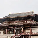 Tradisjonelt japansk tempel med store trebjelker og skråtak, omgitt av en trapp og besøkende