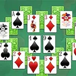 Spillkort arrangert i en halvsirkel med ulike farger og symboler på en grønn bakgrunn