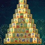 En pyramideformet stabel med mahjong-brikker mot en dekorativ, blomstret bakgrunn