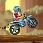 En motorsyklist i rød drakt med blå hjelm kjører en blå motorsykkel over en trestamme med uskarp bakgrunn av skog